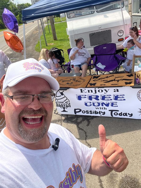 Jim giving a thumbs up in front of the Scoop of Heaven table and ice cream truck